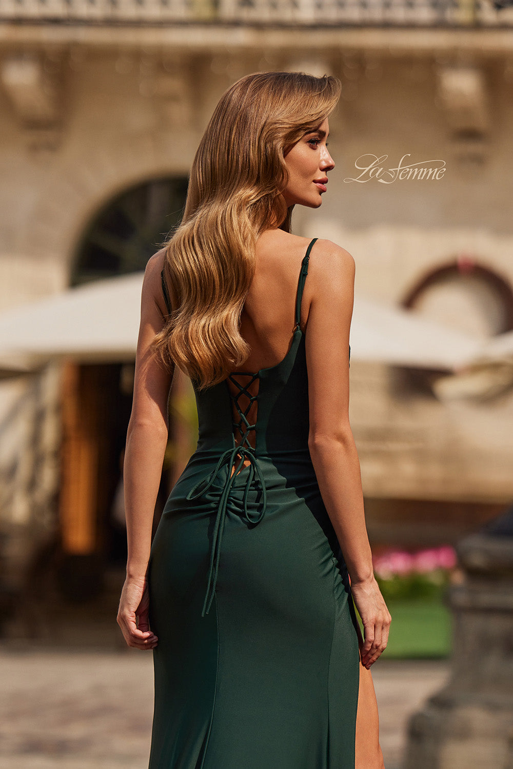 La Femme 33365 Dark emerald mermaid prom dress with a lace-up back and side slit, back view.