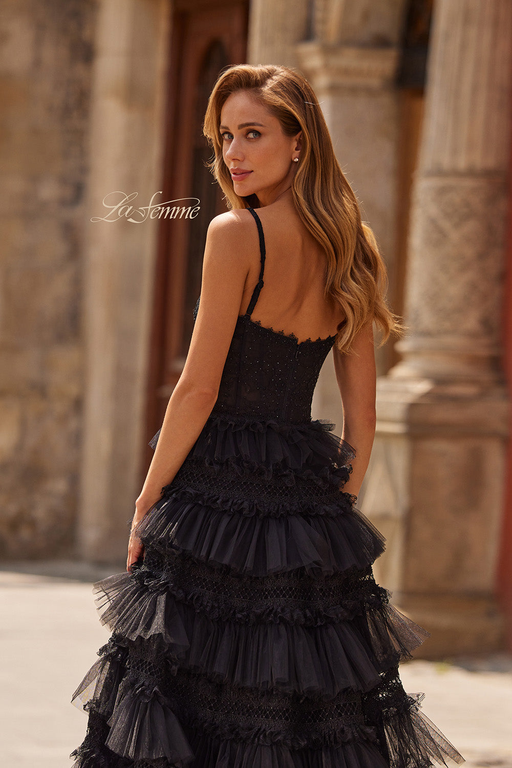 La Femme 33493 Black lace prom dress with tiered ruffles and a corset back, back view.
