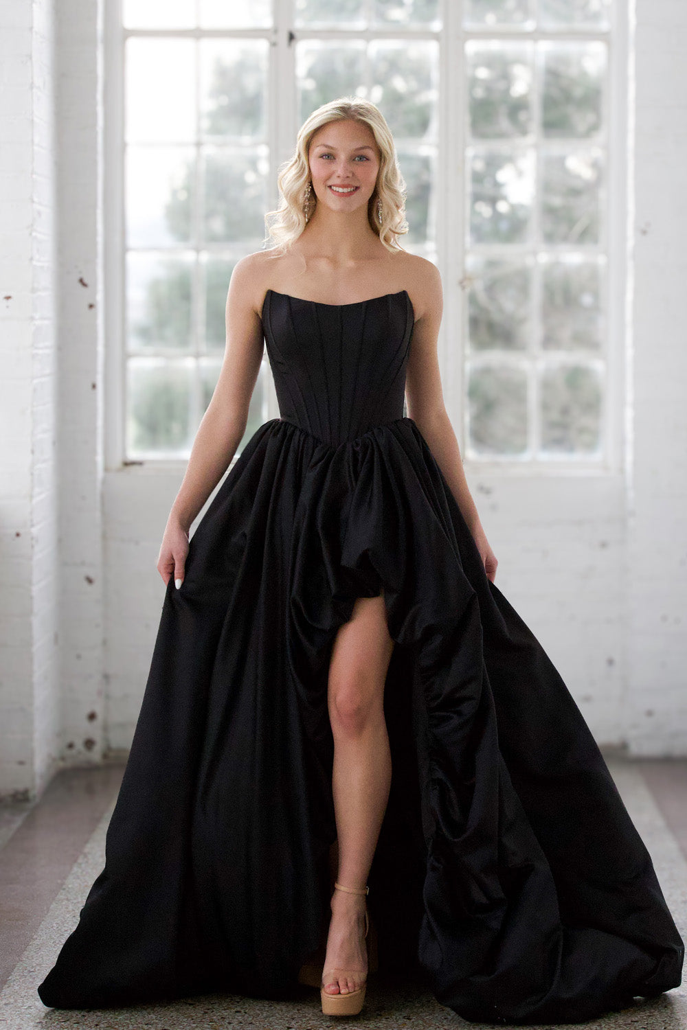 Miah Vega 24601 Black strapless prom dress with a high slit and flowing skirt.