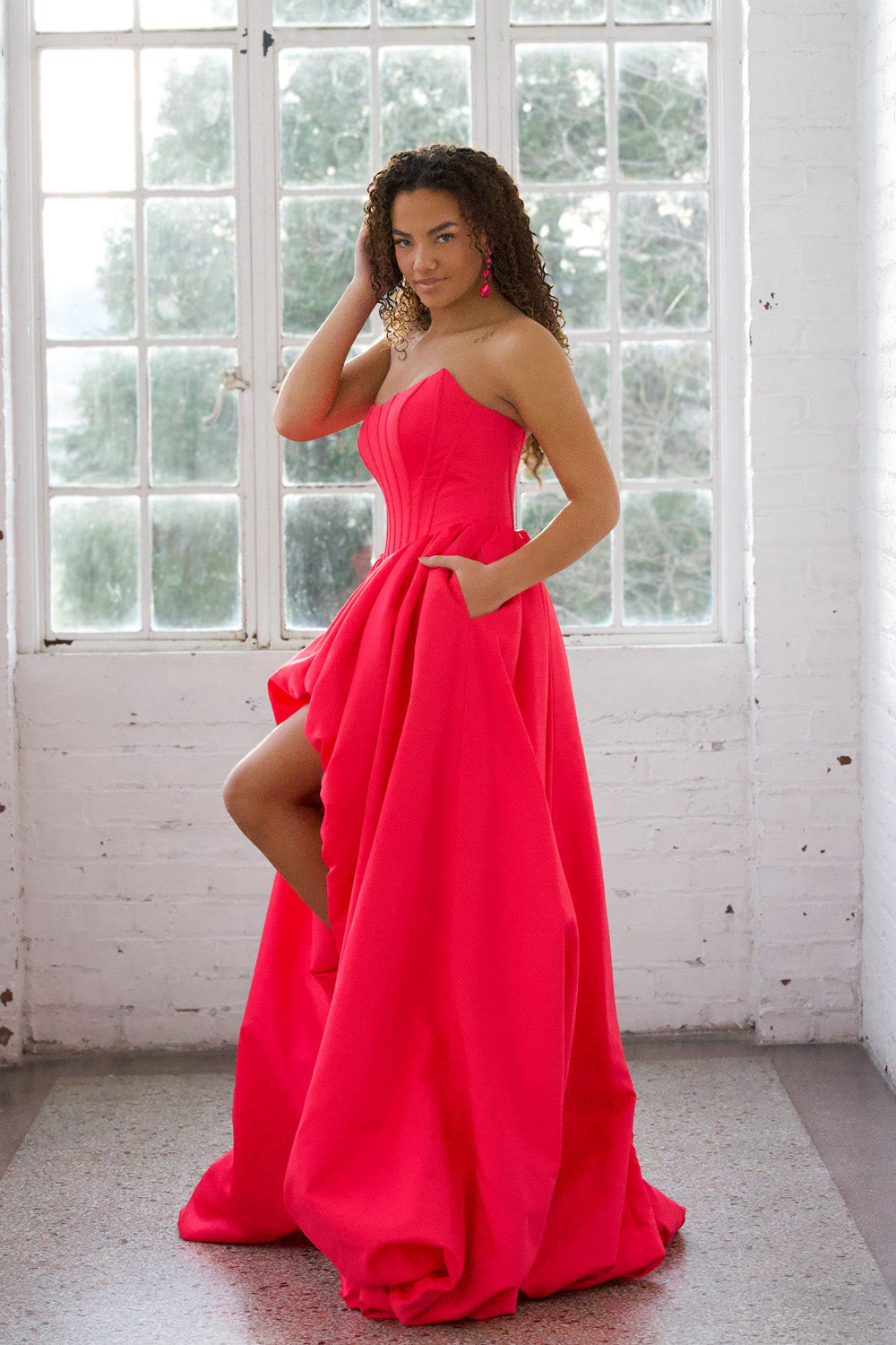 Miah Vega 24601 Bright pink prom dress with a fitted bodice and high slit, side view.