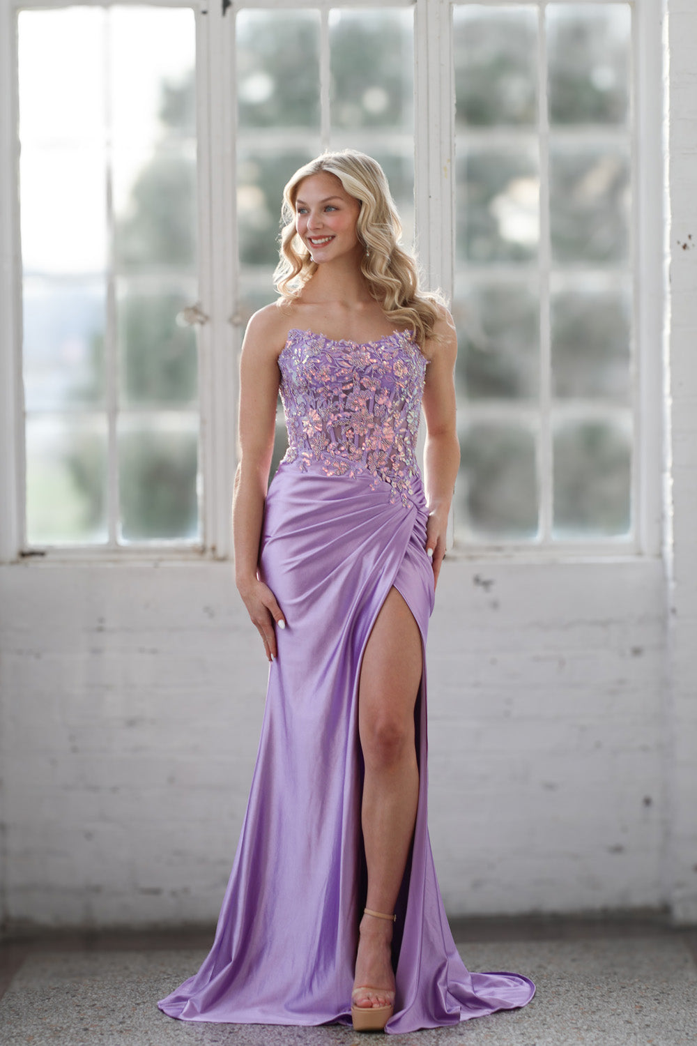 Miah Vega 24607 Lilac prom dress with a fitted silhouette and a thigh-high slit.