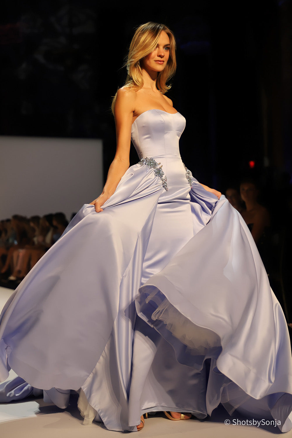 Sherri Hill 46705 periwinkle satin ball gown with gathered overskirt billowing in motion on the runway