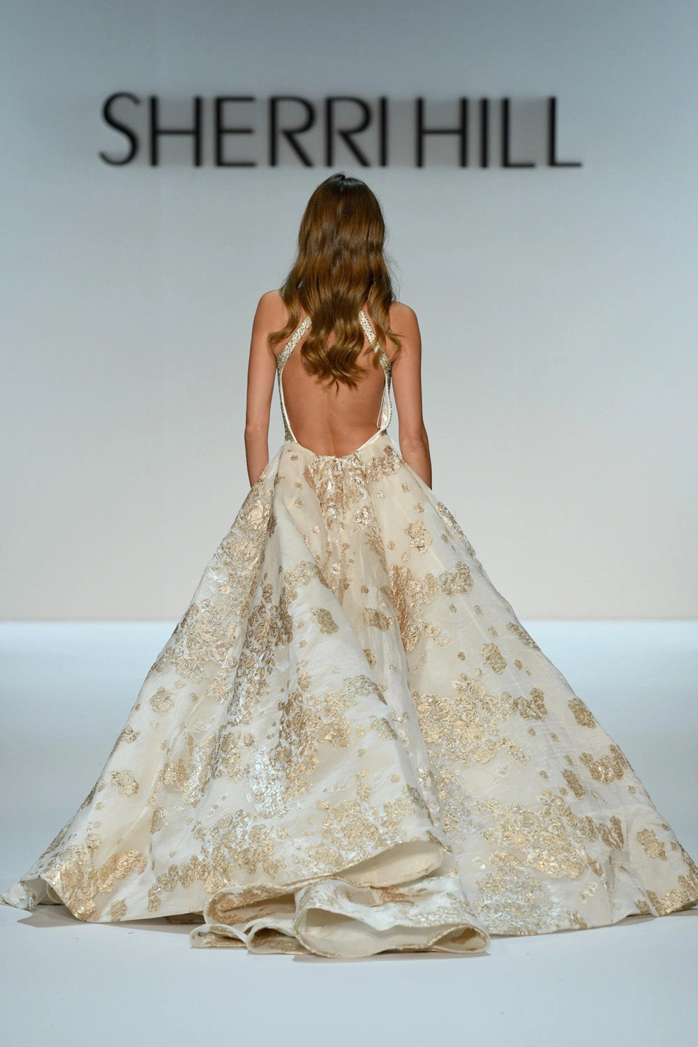 Sherri Hill 46751 ivory gold beaded halter gown with floral jacquard overskirt viewed from behind
