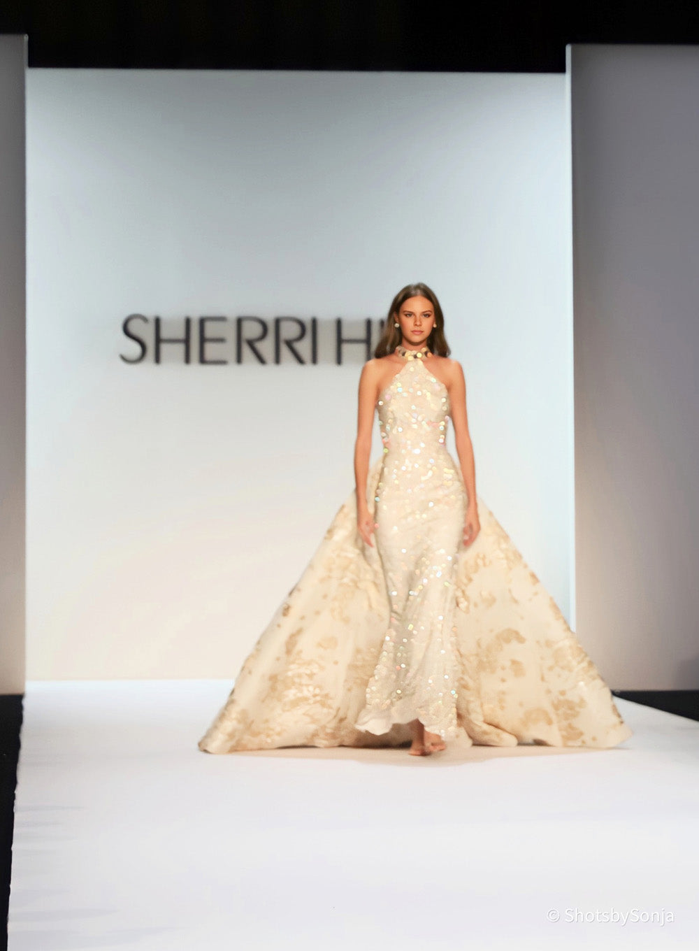 Sherri Hill 46751 ivory gold beaded halter bodice with open overskirt panels on runway