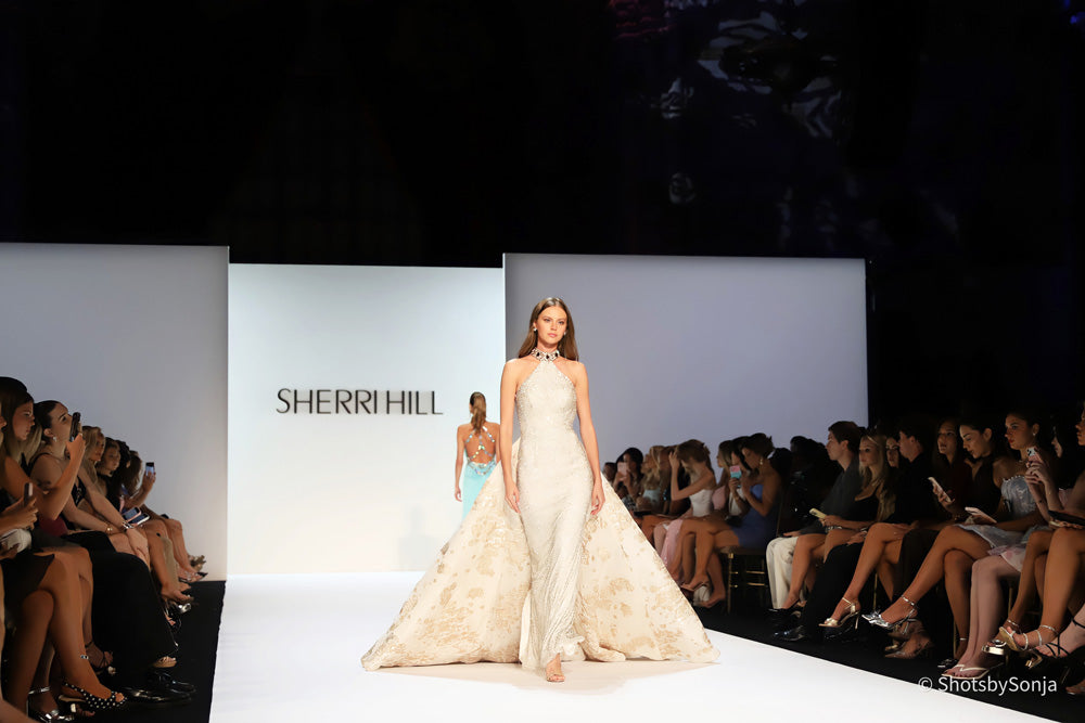 Sherri Hill 46751 ivory gold full silhouette halter gown with voluminous brocade overskirt on runway