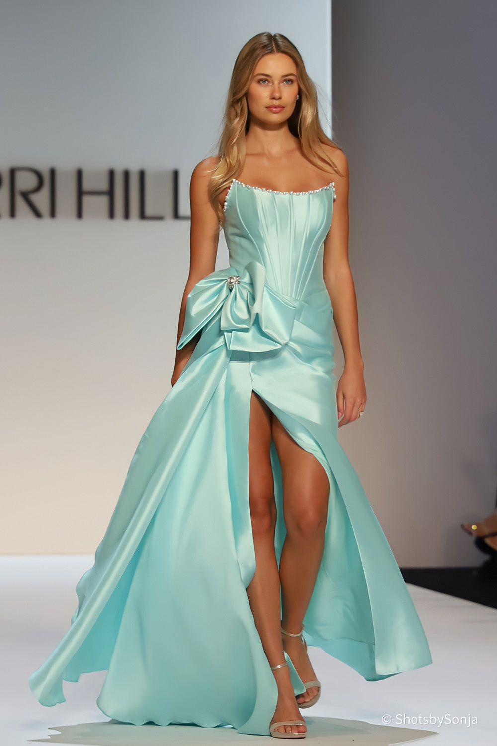 Sherri Hill 58676 aqua satin strapless corset gown with pearl beaded neckline large hip bow and front slit on runway