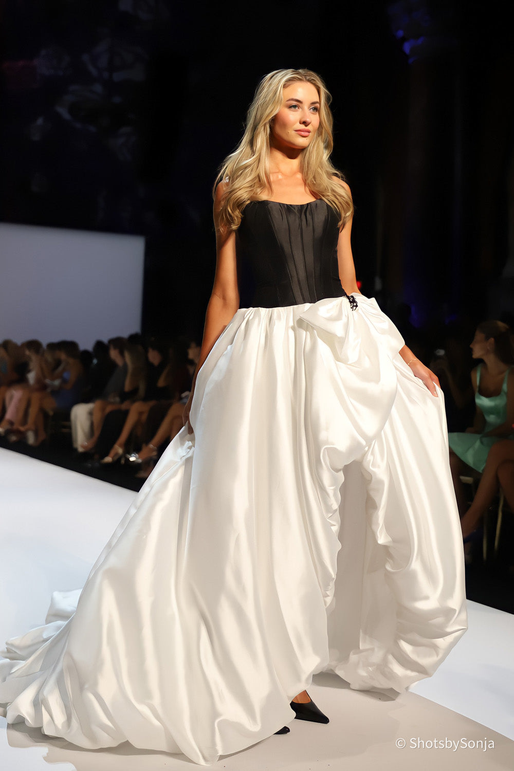Sherri Hill 58768 black corset top and voluminous ivory satin skirt with draped folds in motion on the runway