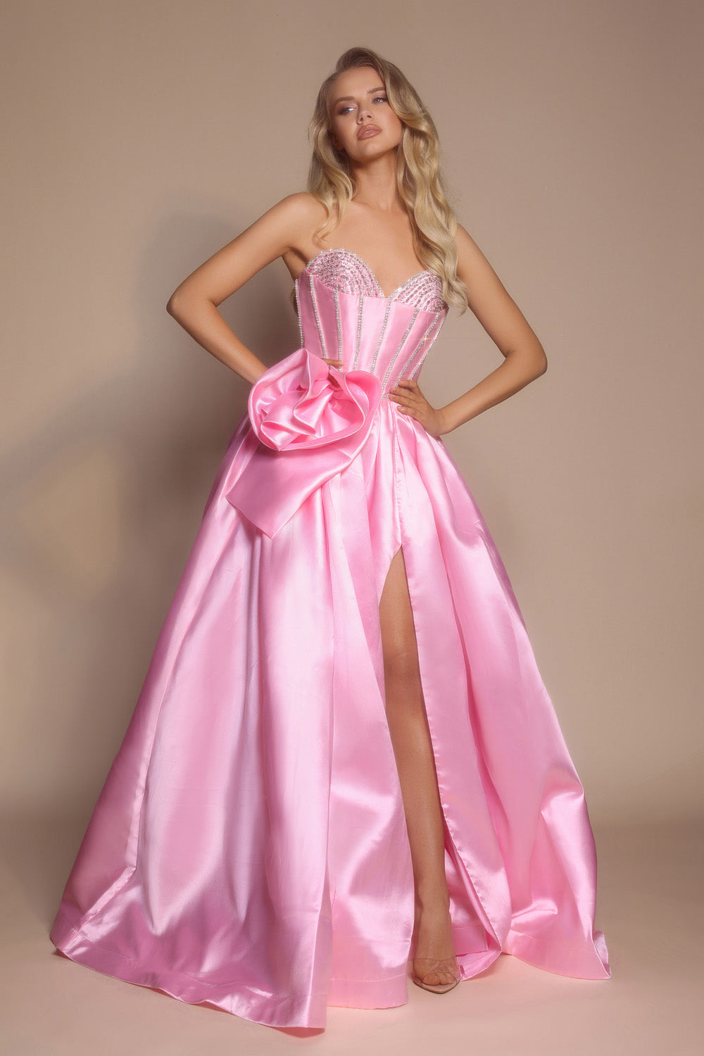 Portia and Scarlett PS26079 Pink prom dress with a fitted bodice, side slit, and oversized bow detail.