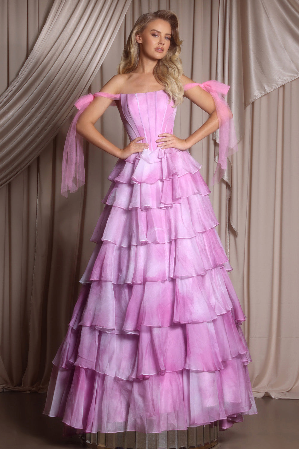 Portia and Scarlett PS26143 Light pink tiered prom dress with off-shoulder sleeves and a fitted bodice.
