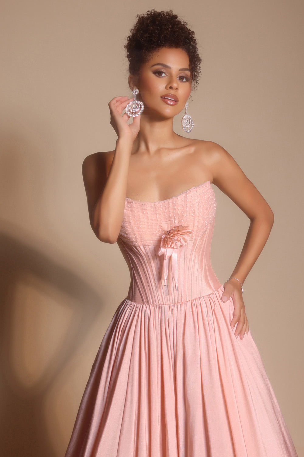 Portia and Scarlett PS26148 Blush prom dress with a fitted bodice and flowing skirt, featuring a floral accent.