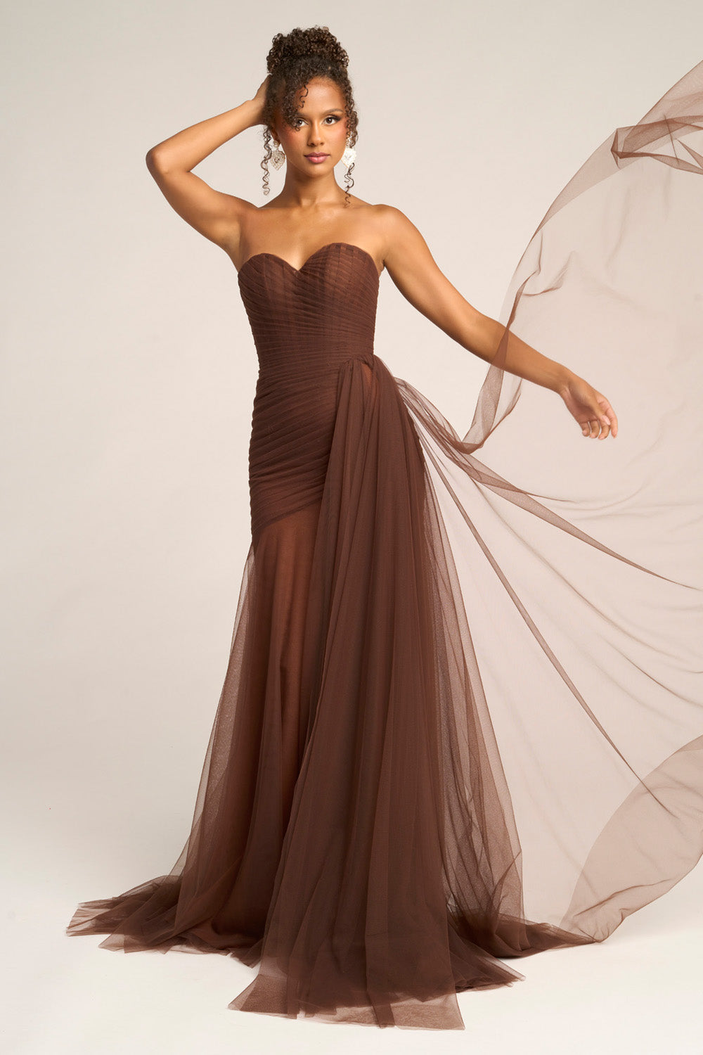 Portia and Scarlett PS26307e Brown mermaid prom dress with a side slit and flowing tulle overlay.