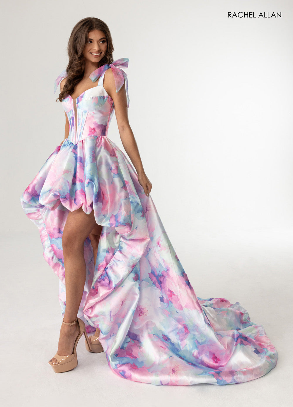 Rachel Allan 70960 A-line prom dress in pink multi with a high slit and bow shoulder straps.