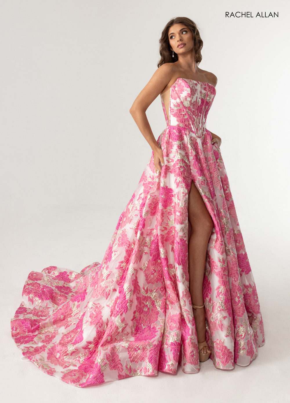 Rachel Allan 70975 Pink multi formal gown with corset bodice and zipper slit, side view.
