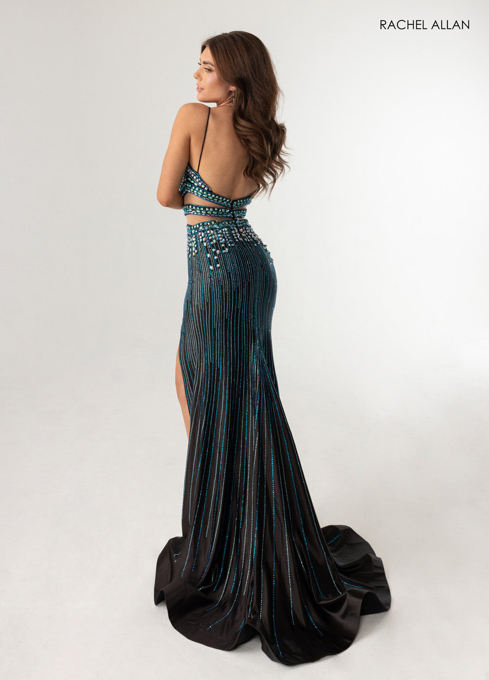 Rachel Allan 71009 Fitted black multi prom dress with crystal beading and a thigh-high slit, back view.