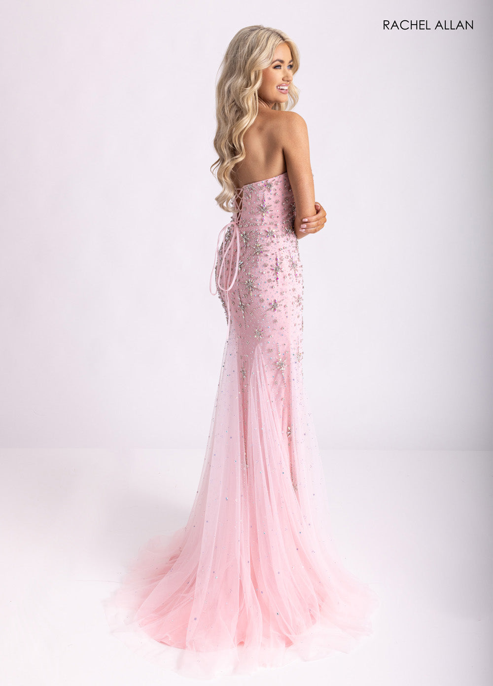 Rachel Allan 71013 Pink mermaid prom dress with crystal beading and lace-up back, side view.