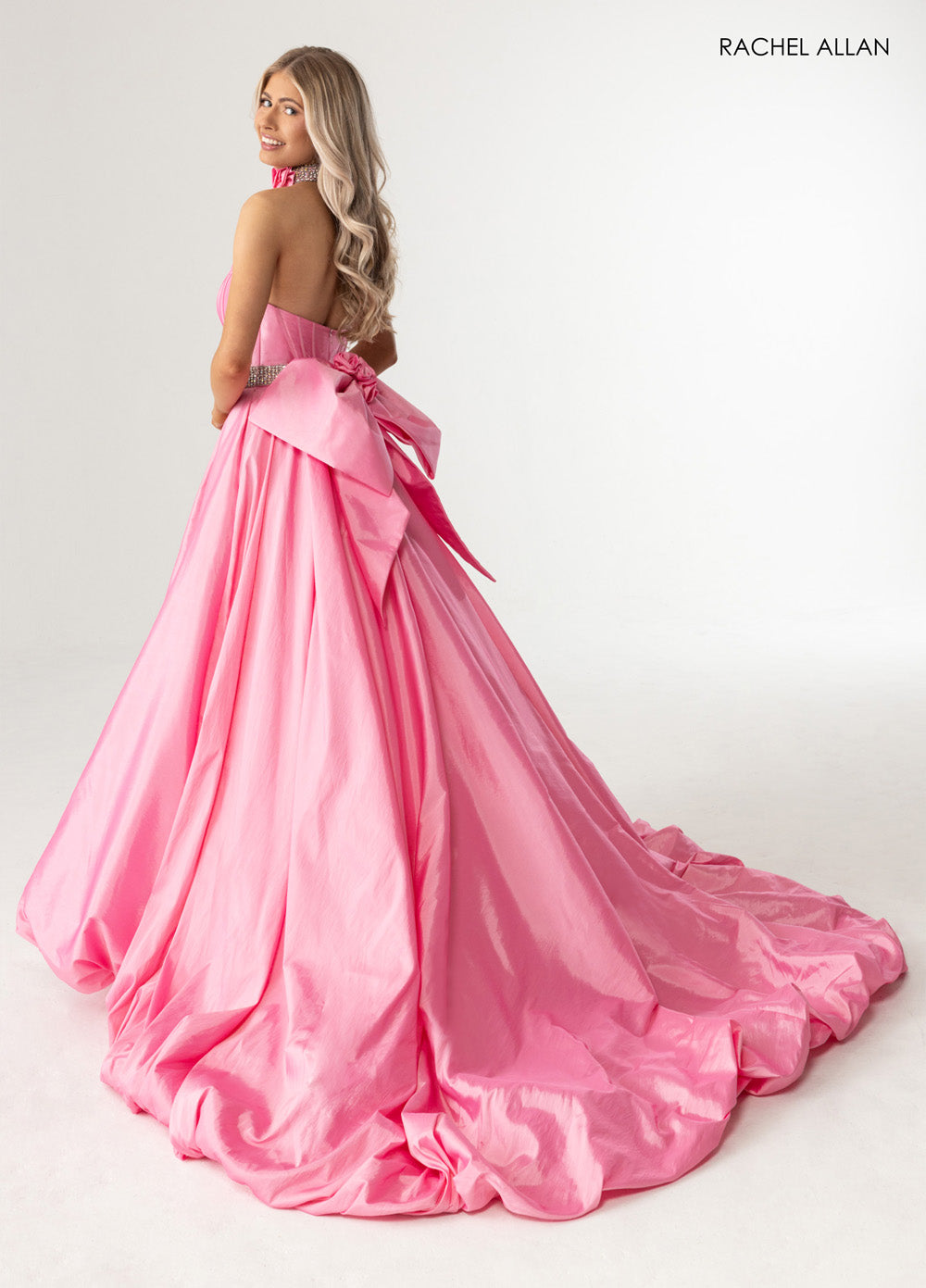 Rachel Allan 71024 Candy pink ballgown with crystal beading and a dramatic bow, back view prom dress.