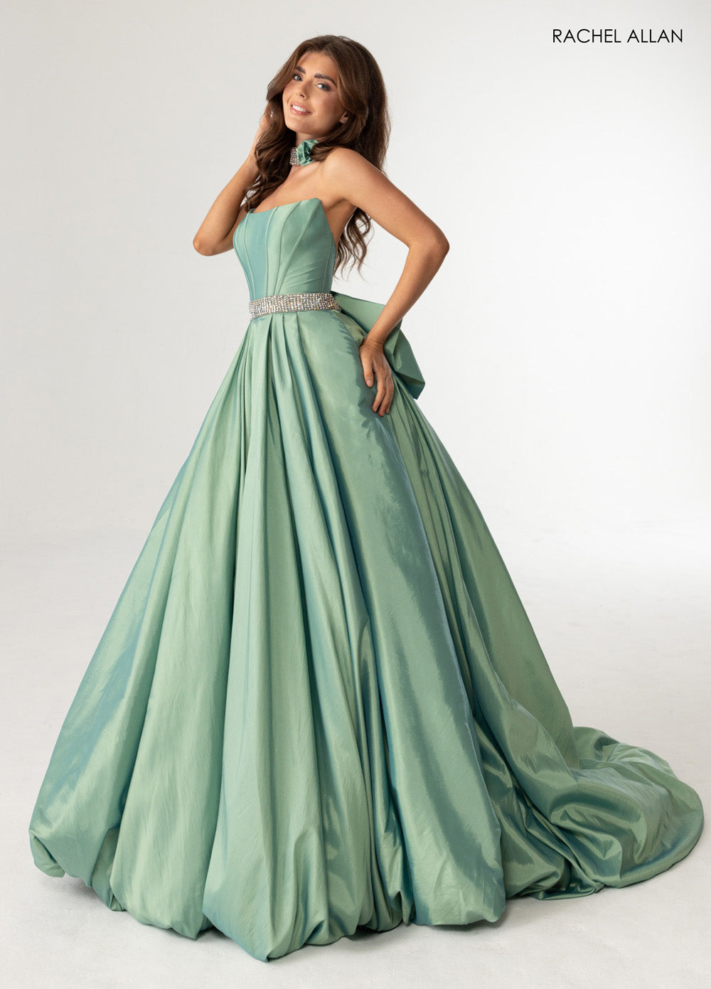 Rachel Allan 71024 Sage green ballgown with crystal beading and a dramatic bow detail prom dress.