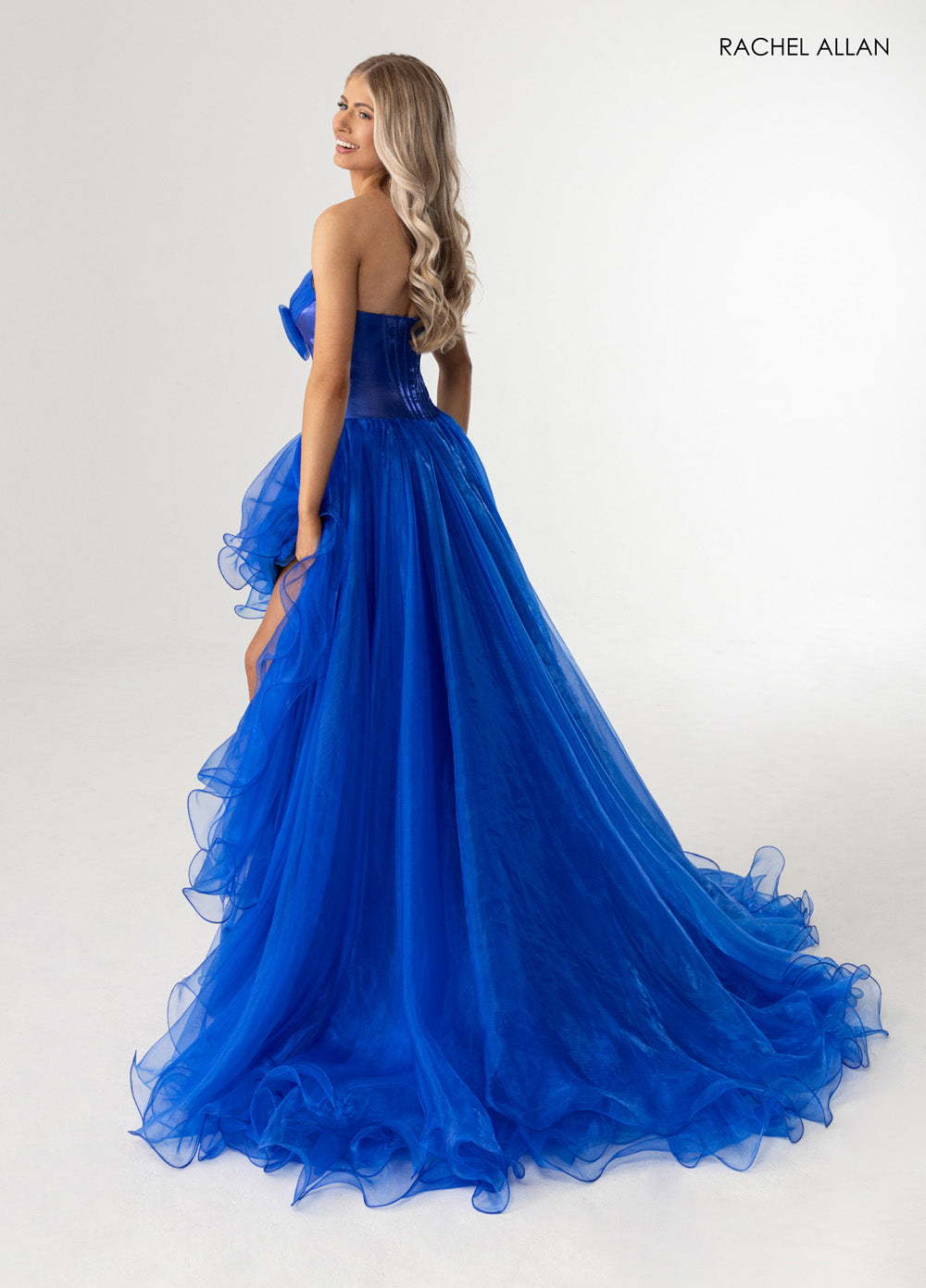 Rachel Allan 71046 Royal blue prom dress with a fitted bodice and dramatic ruffled train.