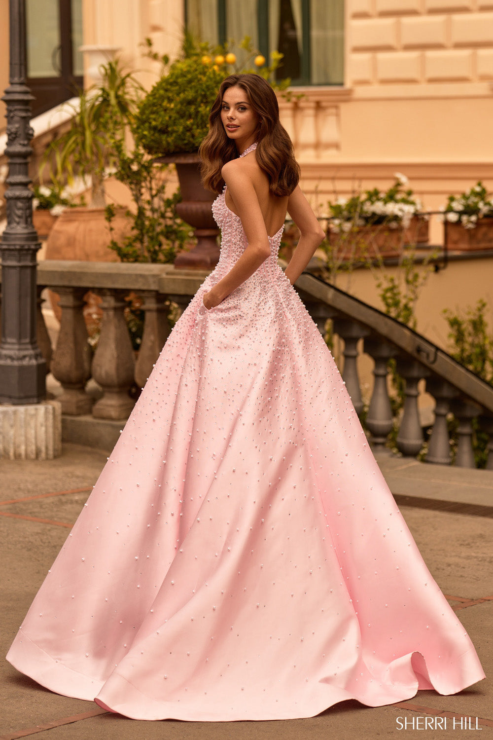 Sherri Hill 58096 pink silver ballgown back view showing open back, halter strap, and voluminous embellished skirt with train.