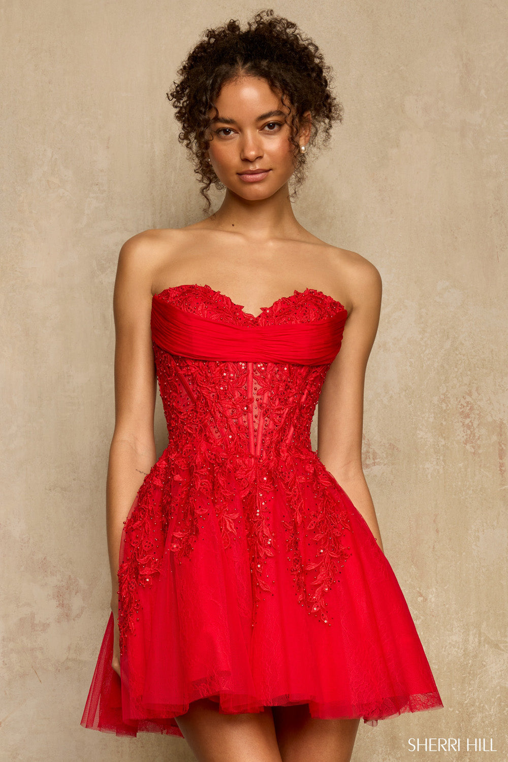 Close front view of Sherri Hill 58116 red corset mini dress with rhinestone-accented lace appliqués cascading onto the skirt.
