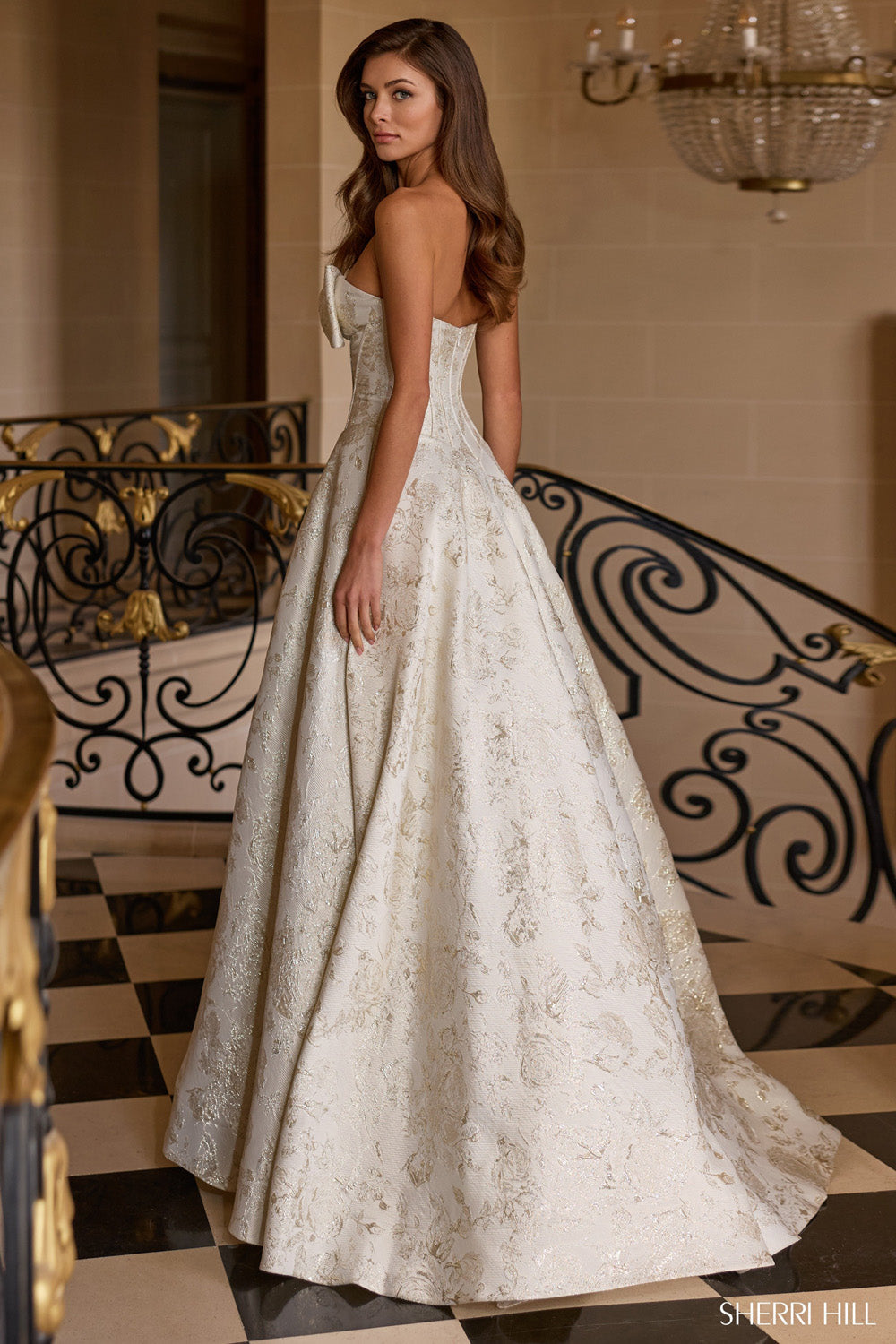 Sherri Hill 58240 sand brocade A-line ballgown back view showing open structured corset back and full floral jacquard skirt.